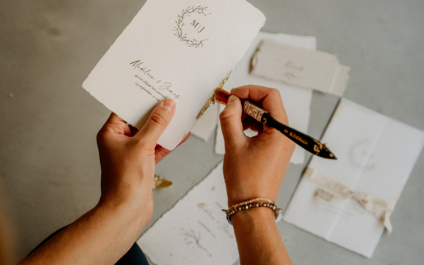 Bladgoud aanbrengen op trouwkaart van handgeschept papier.